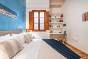 sypialnia z białym łóżkiem i biurkiem w obiekcie Mirtì boutique Apartment heart Cagliari w Cagliari