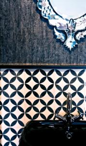 a bathroom with a sink and a mirror on a tiled wall at Riad Dar Saba - Saba's House in Tangier