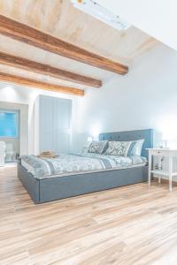 ein Schlafzimmer mit einem Bett und einem Holzboden in der Unterkunft Gunpost Suite in Valletta