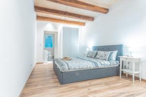 een witte slaapkamer met een bed en een houten vloer bij Gunpost Suite in Valletta