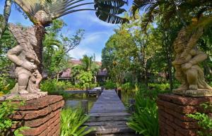 une passerelle en bois traversant un jardin arboré dans l'établissement Annika Koh Chang , Formerly Ramayana Koh Chang Resort & Spa, à Ko Chang