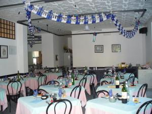 a banquet hall with tables and chairs with wine bottles at Hotel Penny in Rimini