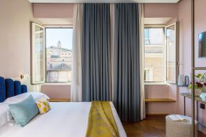 a hotel room with a bed and two windows at Condominio Monti Boutique Hotel in Rome