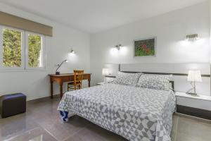 a bedroom with a bed and a desk and a table at Apartment Assimetric - Only 100m to Beach in Alcudia +19 photos