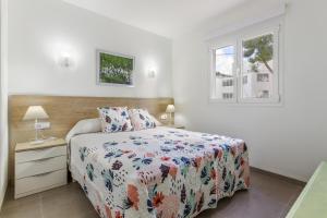 a white bedroom with a bed and a window at Apartment Assimetric - Only 100m to Beach in Alcudia