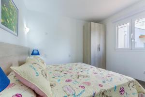a small bedroom with a bed and a window at Apartment Assimetric - Only 100m to Beach in Alcudia