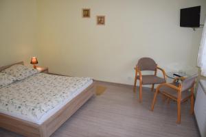a bedroom with a bed and two chairs and a television at Inter-Bar-Motel in Nowe Marzy