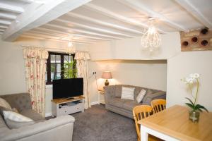 a living room with a couch and a tv at Rutland Water Courtyard Rooms in Oakham