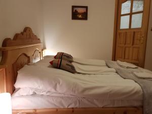 a bedroom with a white bed with a wooden headboard at Polakówka in Poronin