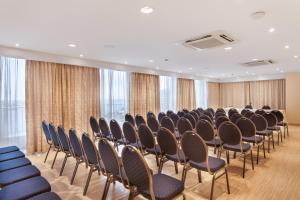 a row of chairs in a room with windows at Plaza Regency Hotels in Sliema