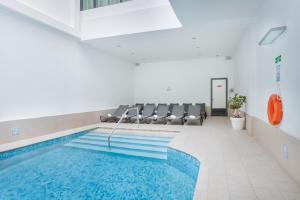 a swimming pool in a room with chairs around it at Plaza Regency Hotels in Sliema