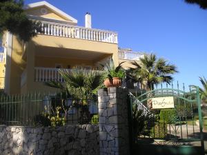 a house with a fence and palm trees at Nikolaos Studios Skala in Skala +11 photos