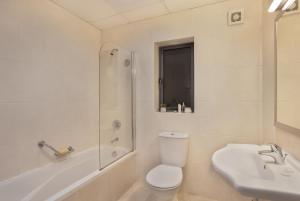 a bathroom with a toilet and a sink and a shower at Plaza Regency Hotels in Sliema