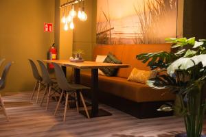 - une table et des chaises dans une chambre avec un canapé dans l'établissement Bed & Breakfast Van Marion, à Oostvoorne