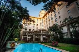 a hotel with a swimming pool in front of a building at Southern Sun Dar es Salaam in Dar es Salaam