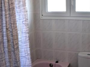 ein Bad mit einem rosa WC und einem Fenster in der Unterkunft Balu in Lloret de Mar