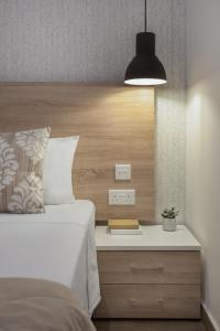 a bedroom with a bed and a nightstand with a lamp at Plaza Regency Hotels in Sliema