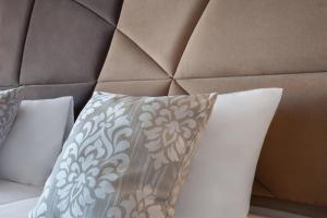 a bed with a brown headboard with a pillow at Plaza Regency Hotels in Sliema