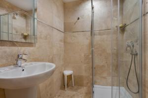 a bathroom with a sink and a shower at Plaza Regency Hotels in Sliema