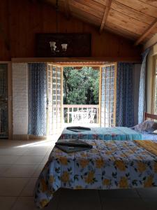 ein Schlafzimmer mit einem Bett und einem großen Fenster in der Unterkunft Parque Paraíso das Flores in Holambra