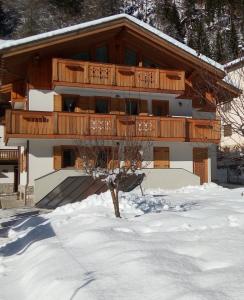 budynek z balkonem w śniegu w obiekcie B&B Il Tulipano w mieście San Pietro di Cadore
