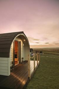 a building with a deck with a fence at Braeside Retreats in Thurso