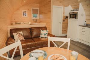 ein Wohnzimmer mit einem Sofa und einem Tisch in der Unterkunft Braeside Retreats in Thurso