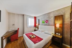 a hotel room with a large bed and a desk at HOTEL RESTAURANT PARIS PACIFIC PARIS-VILLEJUIF- PRES DU METRO L'HAY LES ROSES LIGNE 14 - Direct PARIS-AEROPORT ORLY ET INSTITUT GUSTAVE ROUSSI in Villejuif +30 photos