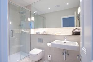 a bathroom with a toilet, sink, and shower at 54 Queen's Gate Hotel in London