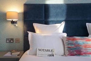 a bed with pillows and pillows on top of it at 54 Queen's Gate Hotel in London