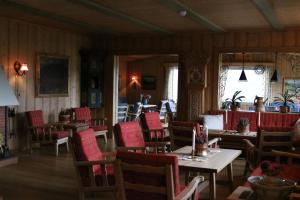 a dining room with red chairs and tables and a room with at Øigardseter Fjellstue in Høvringen
