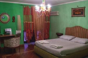 Un dormitorio con una cama con paredes verdes y una lámpara de araña. en b&b Zia Sua, en Nápoles