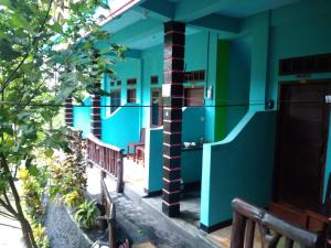 ein Gebäude mit blauen und grünen Wänden und Bänken in der Unterkunft Breeze Hostel in Kuta Lombok
