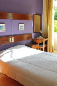 a bedroom with a white bed and a purple wall at Residencial Moderna in Figueira da Foz