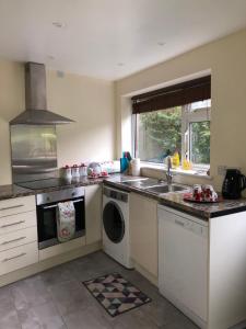a kitchen with a sink and a washing machine at 11 Llainwen Isaf in Llanberis