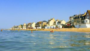 un grupo de personas en el agua en una playa en Papagayo en Saint-Aubin-sur-Mer