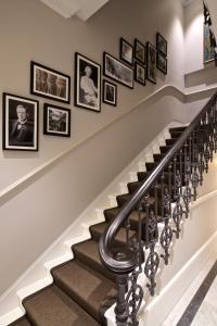 eine Treppe mit gerahmten Bildern an der Wand in der Unterkunft 54 Queen's Gate Hotel in London + 181 Fotos