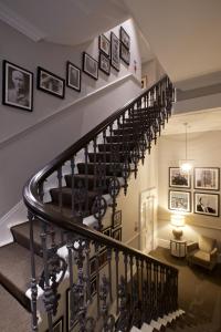 una escalera de caracol con cuadros en la pared en 54 Queen's Gate Hotel, en Londres 37 fotos más