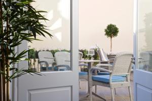 eine Terrasse mit Korbstühlen und einem Tisch in der Unterkunft 54 Queen's Gate Hotel in London