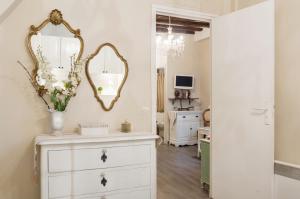 a room with a dresser and a mirror on the wall at Le Jardin Du Marais in Paris