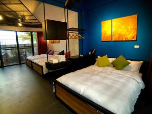1 dormitorio con 2 camas y pared azul en Carefree Homestay en Gukeng
