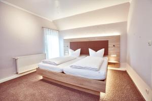 a bedroom with two white beds and a large window at Das Landhotel am Trätzhof Fulda in Fulda