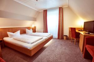 a hotel room with a bed and a desk at Das Landhotel am Trätzhof Fulda in Fulda