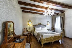 a bedroom with a bed and a table and a mirror at Palazzo San Lorenzo in Venice
