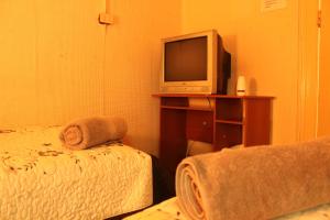 een slaapkamer met een bed en een tv op een tafel bij Hostal Fiorenttina in Valparaíso +22 foto's