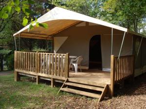 een tent met een veranda met een tafel en stoelen bij Camping les Peupliers in Vendays-Montalivet