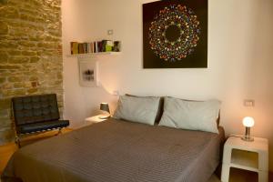 a bedroom with a bed and a chair and a painting at Il Canzoniere in Arezzo