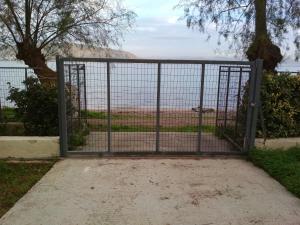 una puerta en un campo con una valla en Seaside Studio, en Salamina