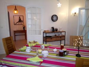 a dining room with a table with a striped table cloth at Chambres d'hôtes Toulaho in Cazères