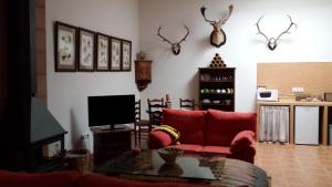 a living room with a red couch and a table at Agroturismo la finka in Los Quiles